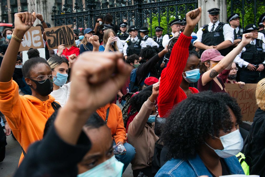 Demonstrators raise their fists while observing a minute of silence during a demonstration for George Floyd outside the Houses of Parliament, on Wednesday.