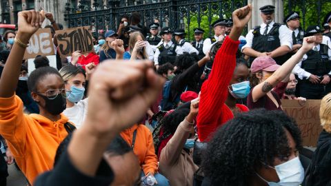 Demonstrators raise their fists while observing a minute of silence during a demonstration for George Floyd outside the Houses of Parliament, on Wednesday.