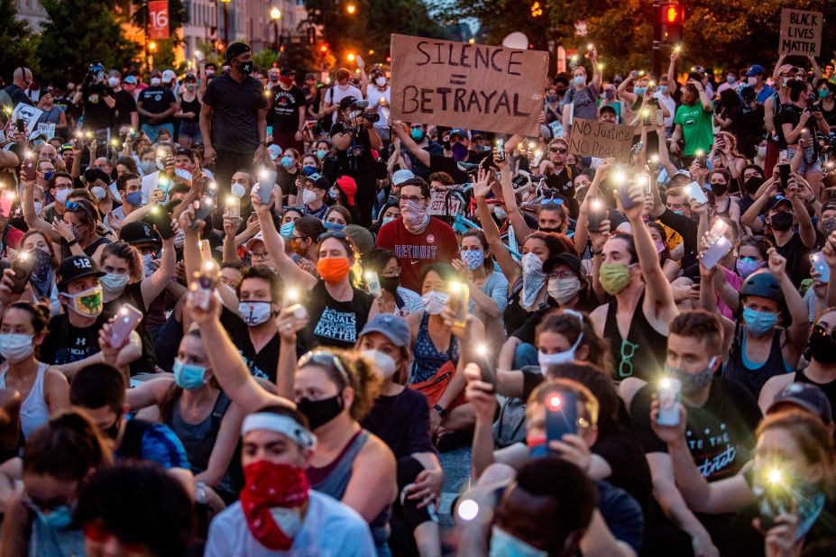 Protesters hold up their phones during a demonstration outside the White House on June 3.