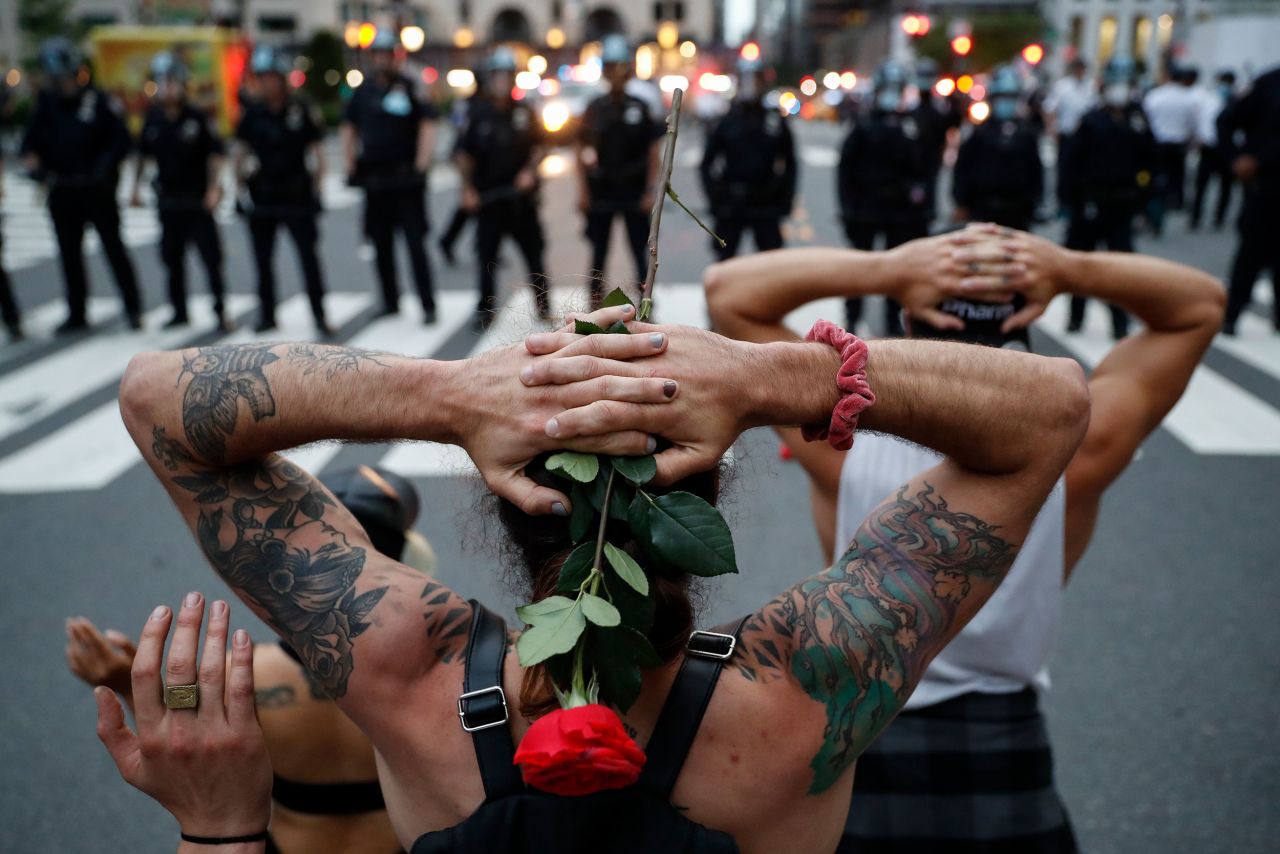 Protesters kneel in front of New York City police officers before being arrested for violating curfew on June 3.