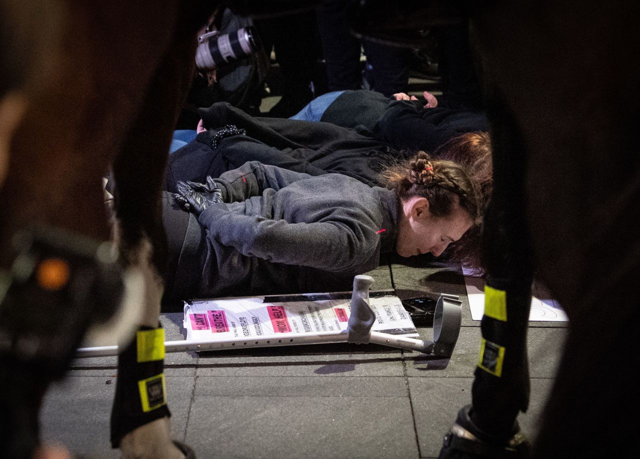 Protesters lie on the ground in front of a line of mounted police in Sydney on Tuesday.