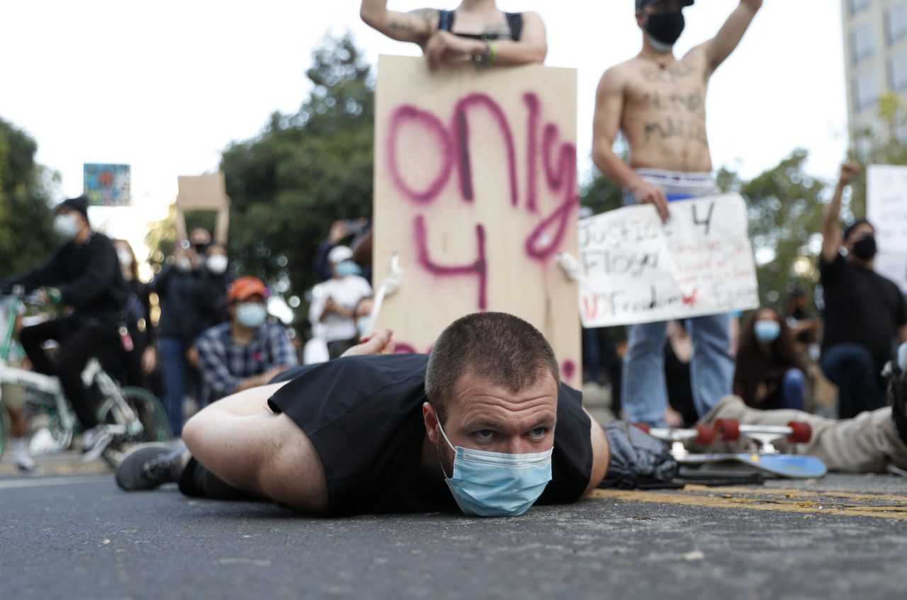A protester lies on the ground in front of police officers in San Jose, California, on Monday.
