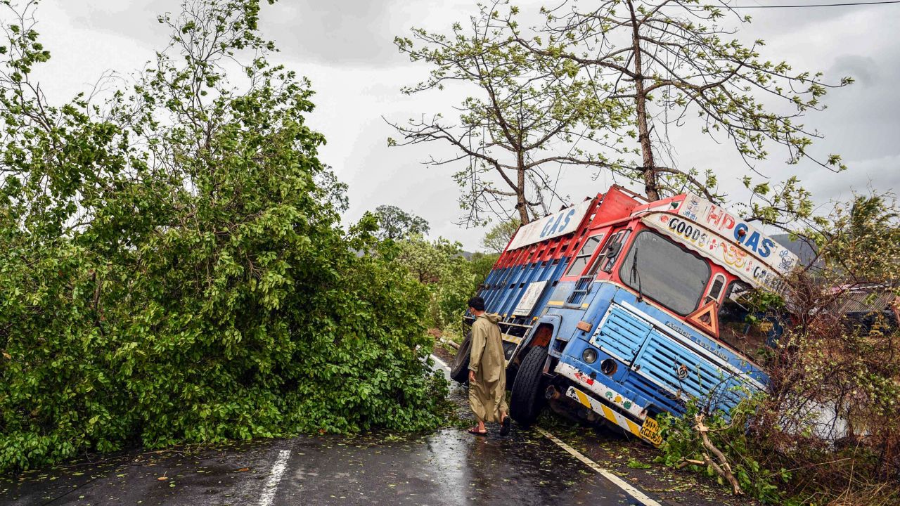 A truck is seen off the road near uprooted trees that have fallen on a main road in Alibag town of Raigad district, following Cyclone Nisarga.