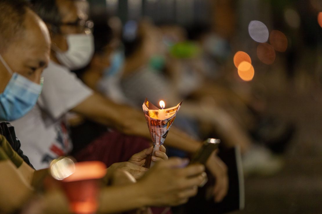 A man holds a candle at Thursday's vigil. 