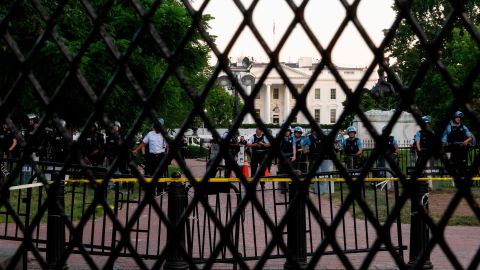 A line of policemen keep guard near a metal fence recently erected in front of the White House and meant to keep protestors at bay on June 2, 2020.