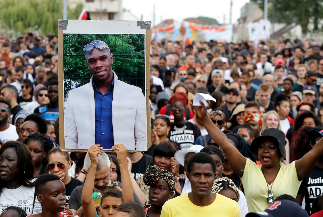 A person holds a portrait of late Adama Traore during a march in Beaumont-sur-Oise, northeast of Paris in 2018 calling for answers in the case.