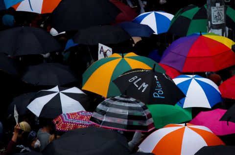 Protesters use umbrellas during a protest in Seattle on June 3.