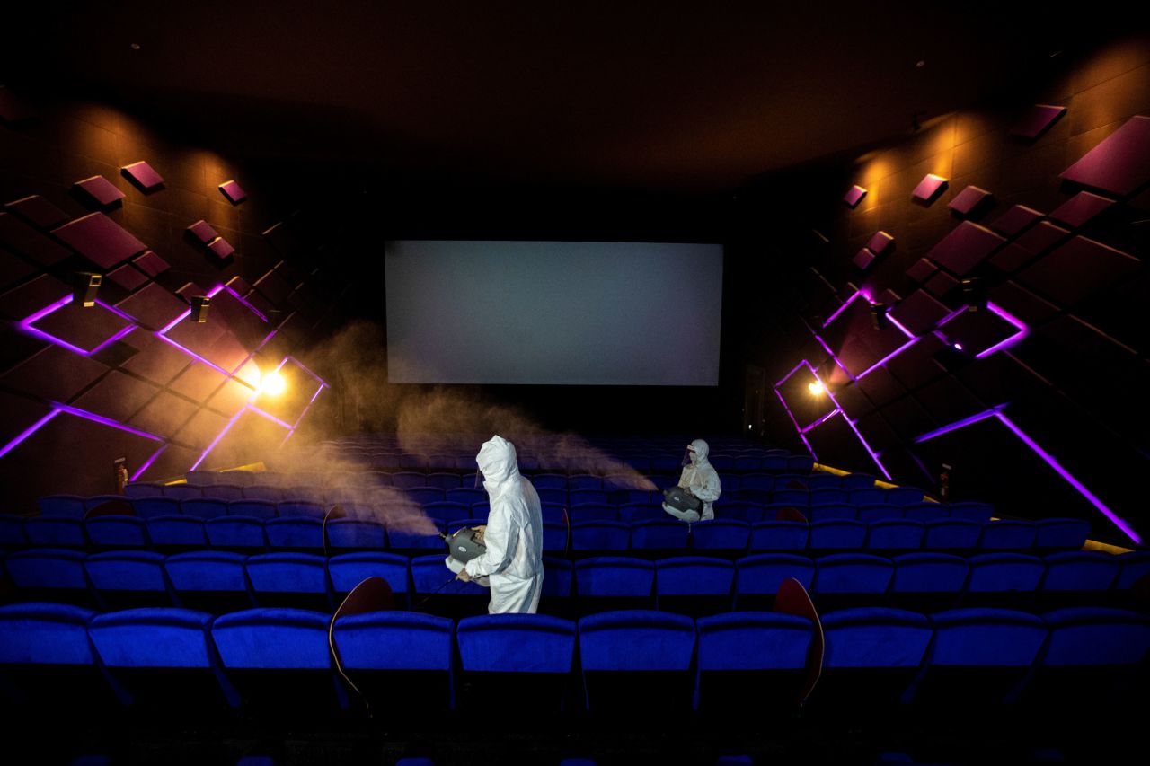 Workers spray disinfectant inside a movie theater in Bangkok, Thailand, ahead of its reopening on May 31, 2020. 