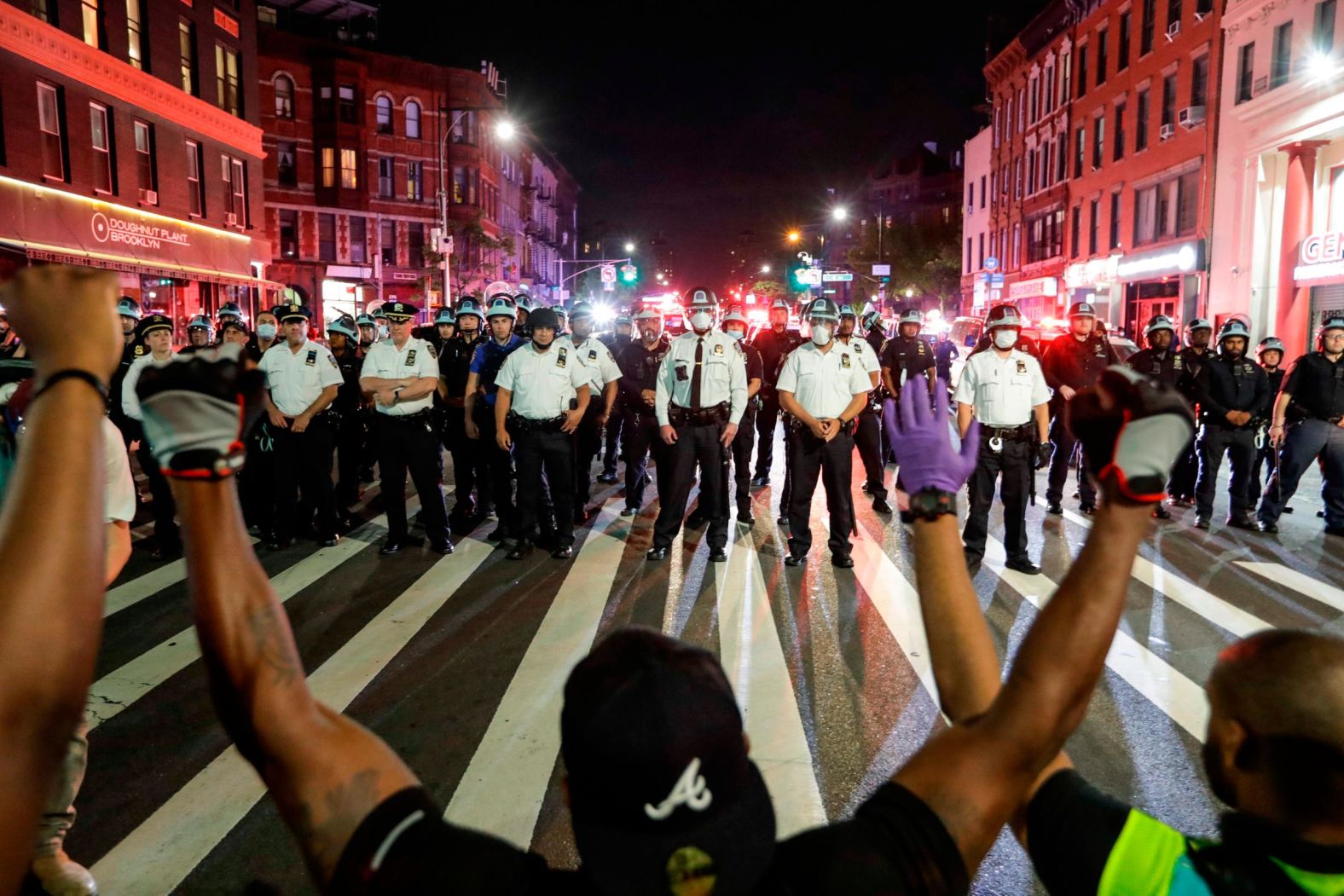 Protesters take a knee in front of a line of police officers in Brooklyn, New York, on June 4.