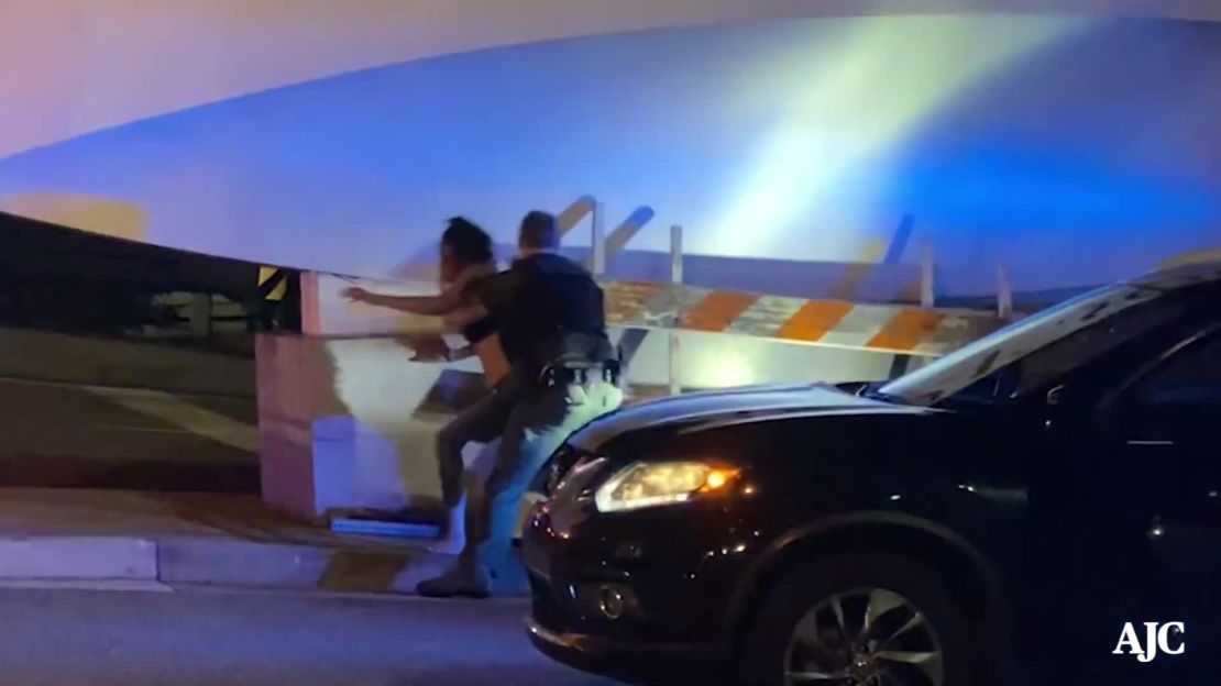 A woman, identifed by her attorney as Amber Jackson, is seen in this still image from Atlanta Journal-Constitution footage being grabbed by an Atlanta police officer on May 29.