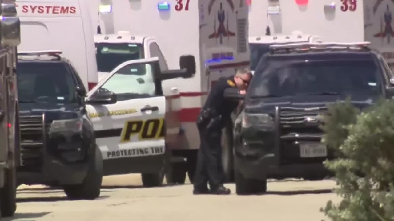 Police on the scene in San Antonio, Texas, where two adults and four children were found dead in an SUV in a garage.