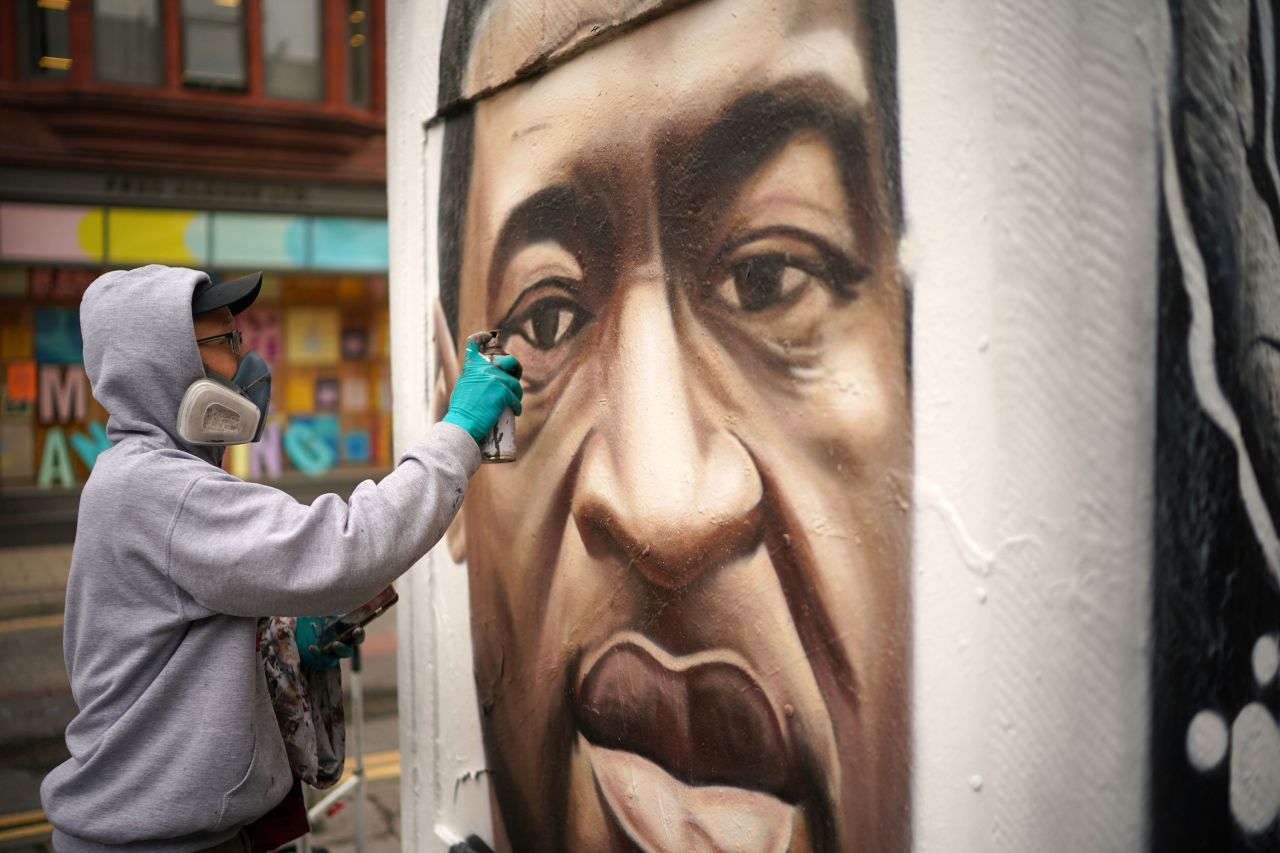 Graffiti artist Akse spray-paints a Floyd mural in Manchester, England, on June 3.