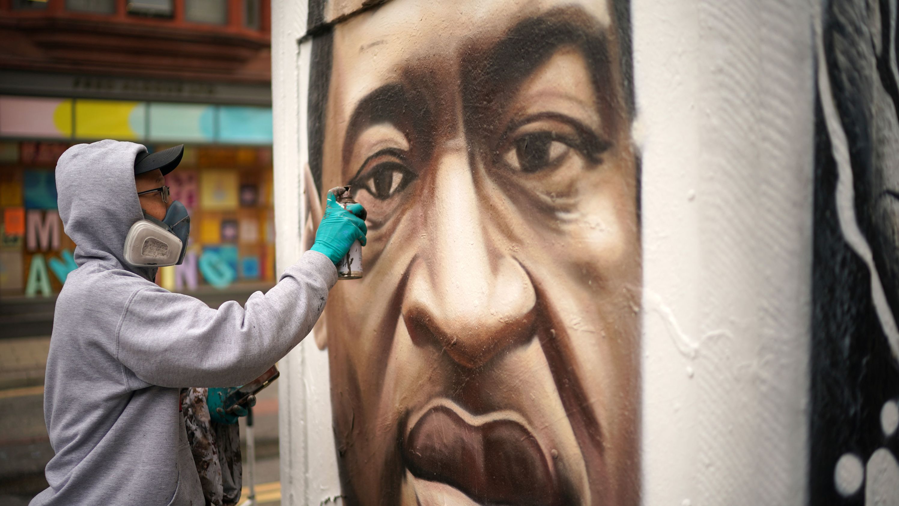 Graffiti artist Akse spray-paints a Floyd mural in Manchester, England, on June 3.