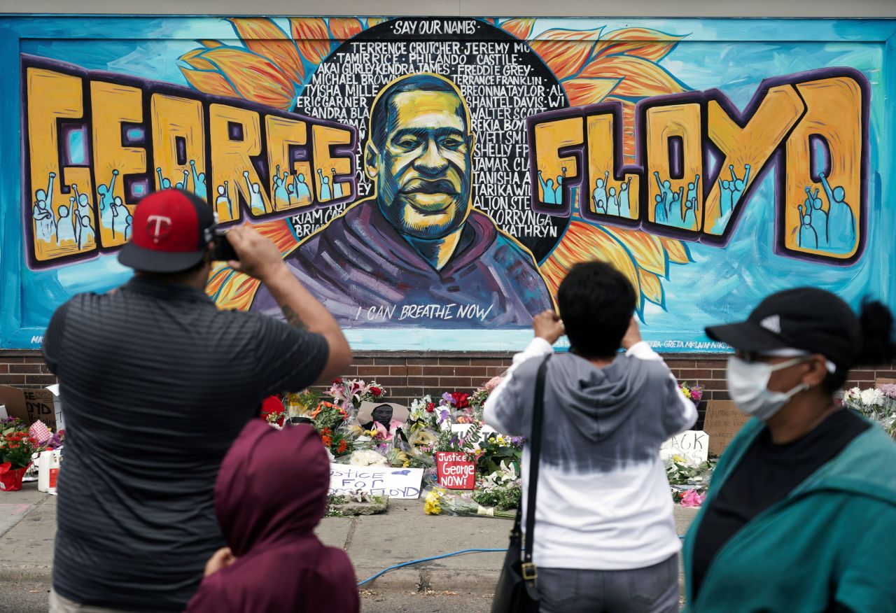 People gather at a George Floyd mural in Minneapolis on May 29. <a href="https://www.cnn.com/style/article/george-floyd-mural-social-justice-art/index.html" target="_blank">The mural</a> was painted by Greta McLain, Xena Goldman and Cadex Herrera at the spot where Floyd was killed.
