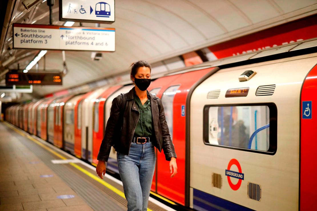 A commuter wears a face mask as she disembarks at a Tube station in London on June 5.