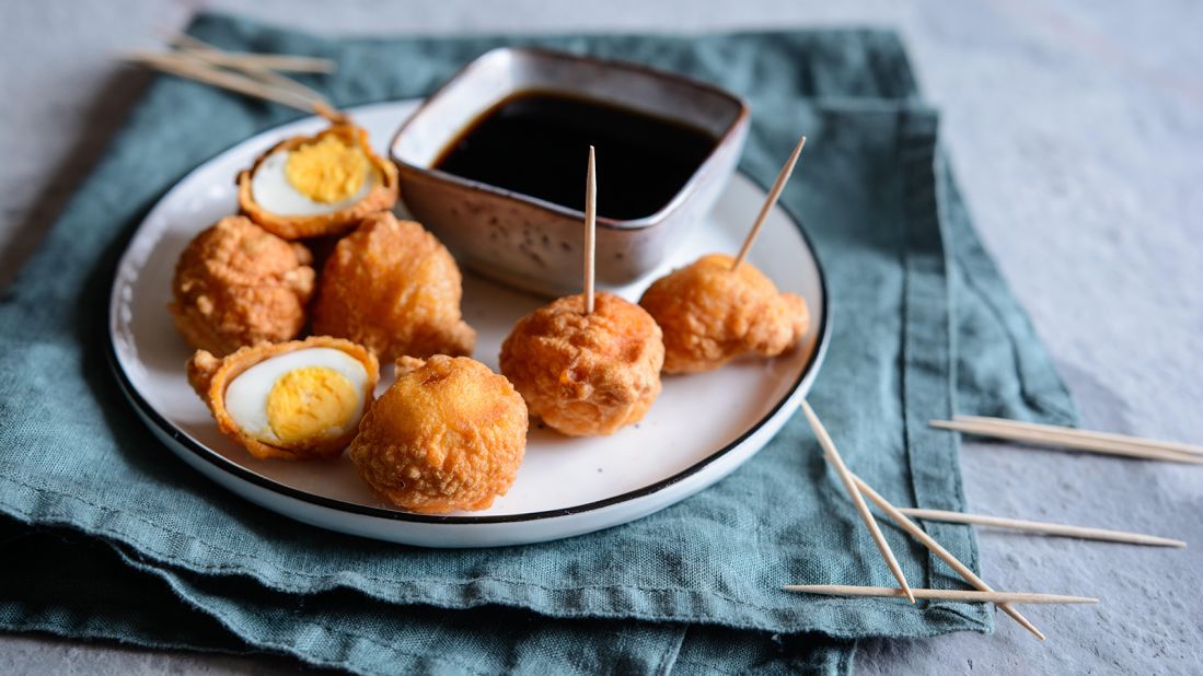 <strong>Kwek kwek</strong>: This Filipino street food is served on a stick of deep fried quail eggs coated with batter served with soya sauce and vinegar dip.