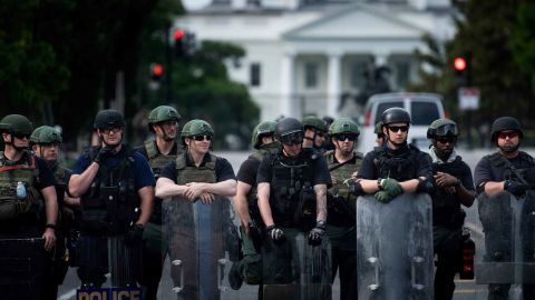 A Federal Bureau of Prisons riot team and other law enforcement officers block 16th Street near the White House.