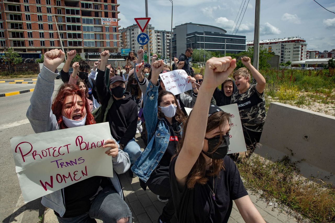 Protesters kneeling and raising their fists during a rally near the U.S Embassy in Pristina, Kosovo.