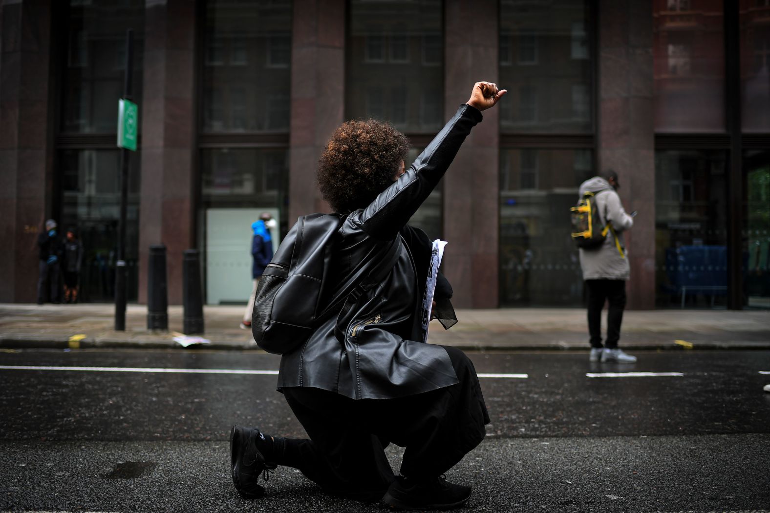 A woman kneels during a rally in London.