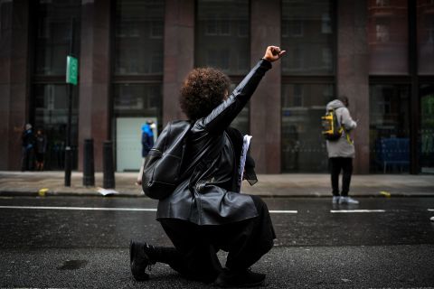 A woman kneels during a rally in London.