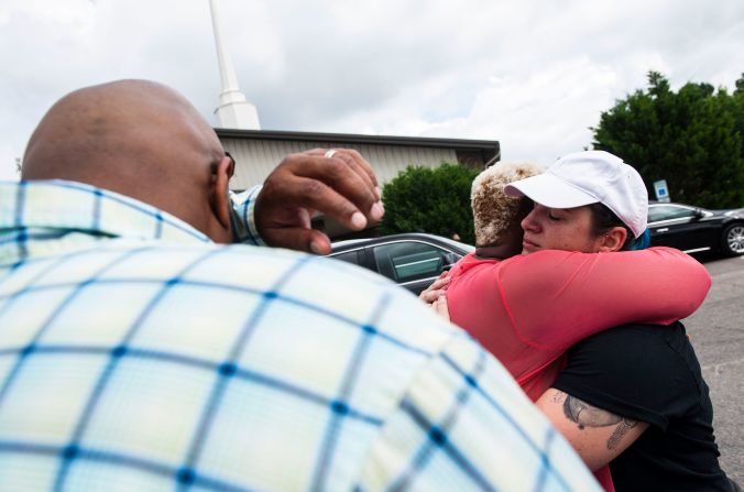 Nakia Almond hugs Erin Corner after praying together outside of Floyd's memorial service in Raeford.
