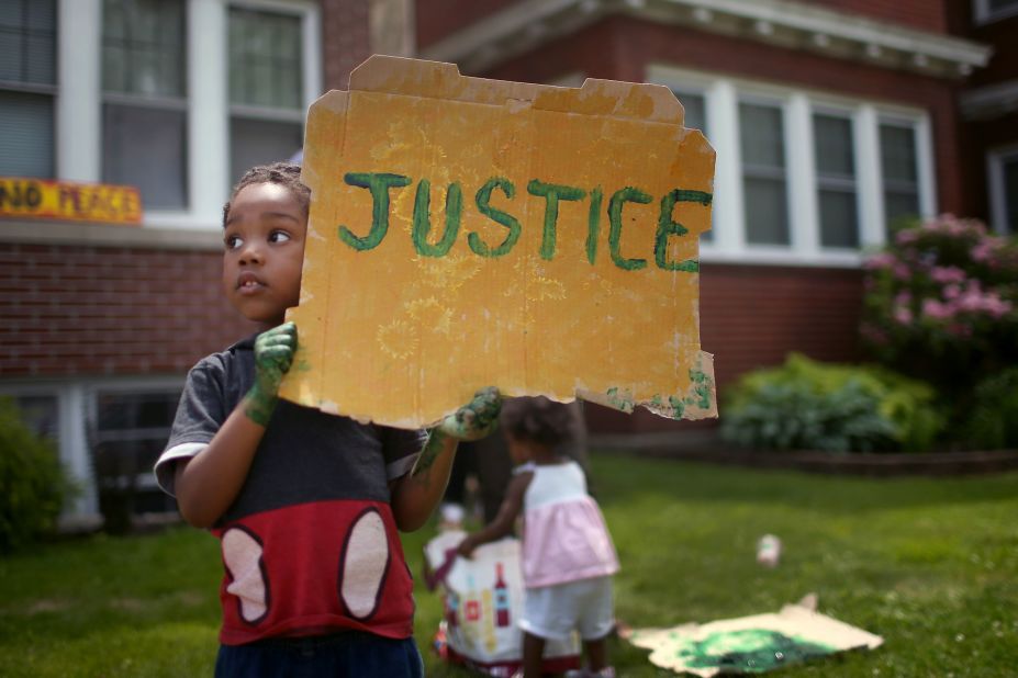 Xavier Brown shows his support as demonstrators march past his home in St. Paul, Minnesota, on June 6.