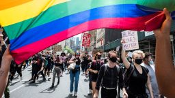 MANHATTAN, NY - JUNE 02: Two protesters carry a pride rainbow flag over their their head while a white protester wearing a mask is seen under the flag with a sign that says, "Black Lives Matter" and the other has a sign that says, "No One Is Free Until All Are Free"as they march with the massive crowd of protesters as they walk from Foley Square to Washington Square Park for a peaceful moment of reflection for those that have been killed.  Protesters took to the streets across America after the killing of George Floyd at the hands of a white police officer Derek Chauvin that was kneeling on his neck during his arrest as he pleaded that he couldn't breathe. The protest are attempting to give a voice to the need for human rights for African American's and to stop police brutality against people of color.  Many people were wearing masks and observing social distancing due to the coronavirus pandemic.  Leaders of the protest were clear that they wanted it to be a peaceful protest in light of nights of unrest looting and destruction.  Photographed in the Manhattan Borough of New York on June 02, 2020, USA.  (Photo by Ira L. Black/Corbis via Getty Images)
