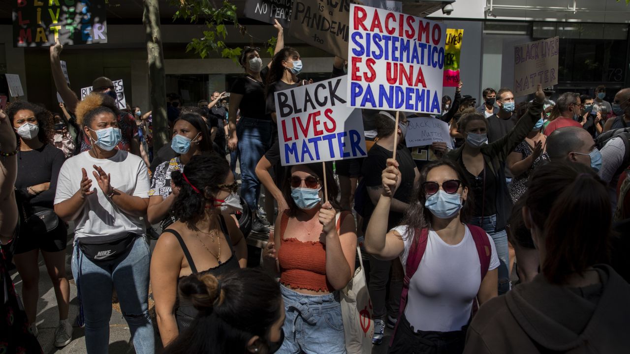 In Madrid, a protester warns that "Systemic racism is a pandemic." 