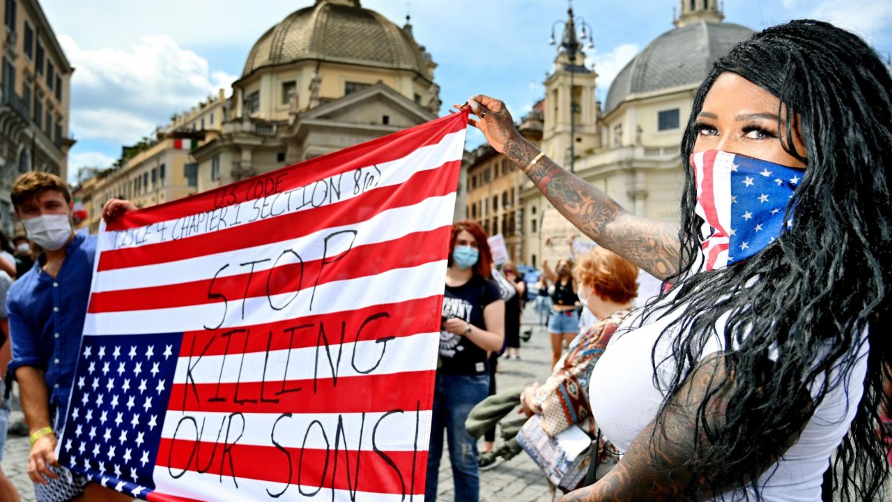 Protesters hold an upside-down US flag in Rome.