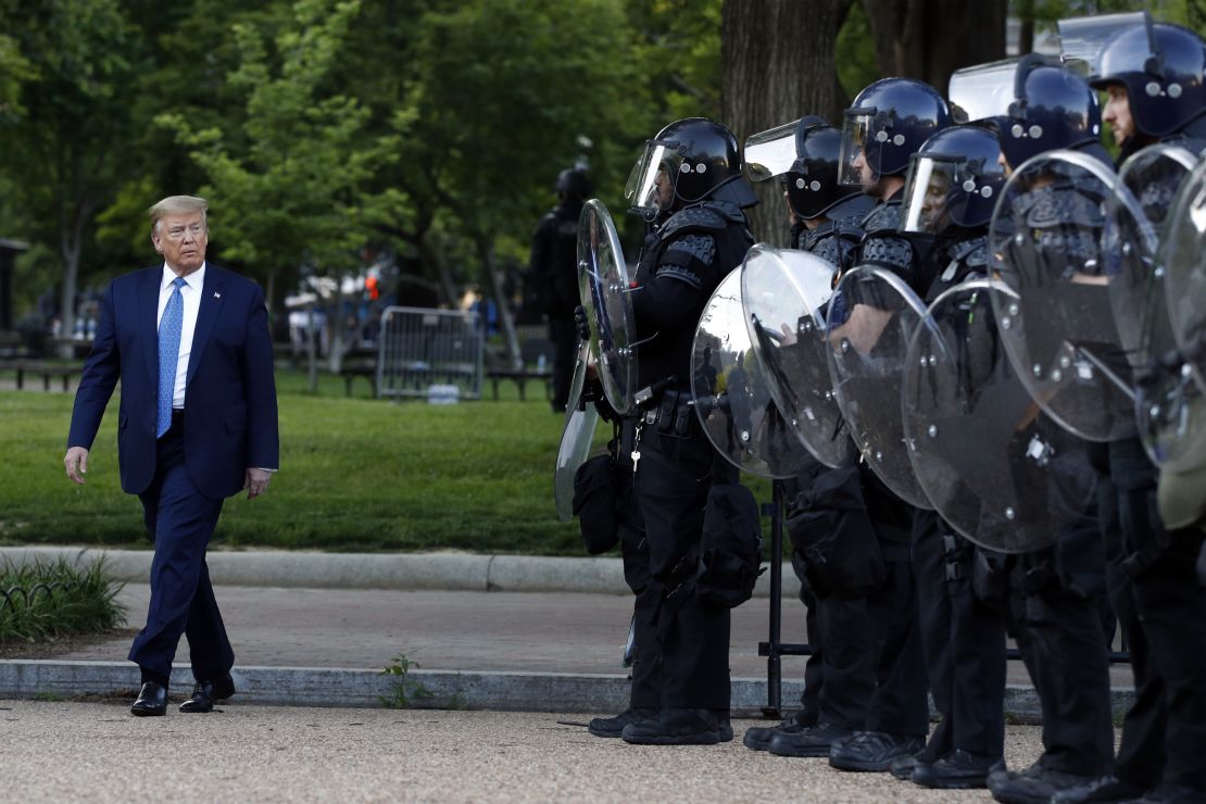 President Donald Trump walks past police in Lafayette Park after he visited St. John's Church across from the White House on Monday, June 1, 2020.