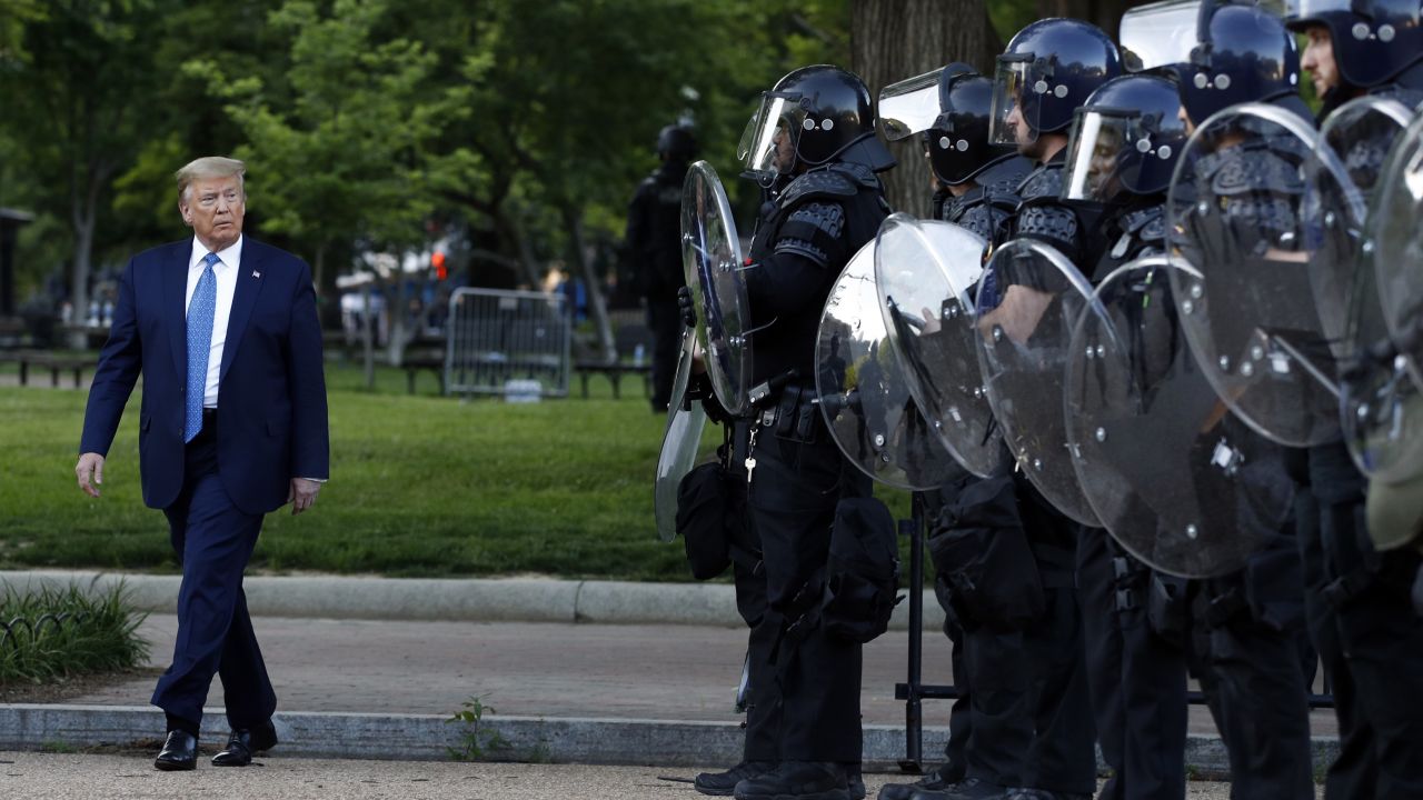 President Donald Trump walks past police in Lafayette Park after he visited outside St. John's Church across from the White House.