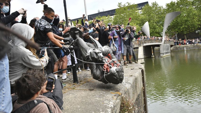Protesters throw a statue of slave trader Edward Colston into Bristol harbour, during a Black Lives Matter protest rally, in Bristol, England, Sunday June 7, 2020, in response to the recent killing of George Floyd by police officers in Minneapolis, USA, that has led to protests in many countries and across the US. (Ben Birchall/PA via AP)