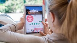 A woman installs the Airbnb application on a tablet.