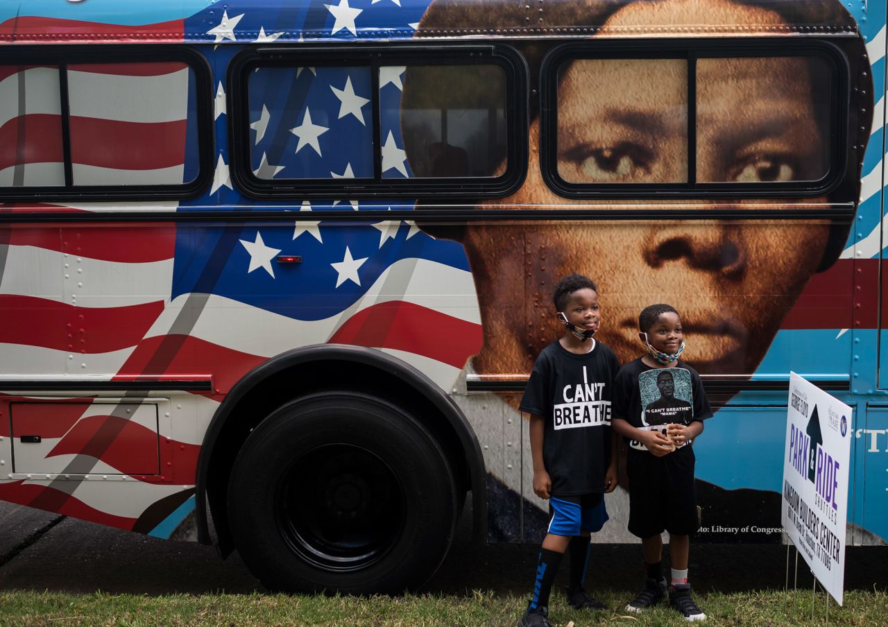 Children pose in front of a bus depicting abolitionist Harriet Tubman.