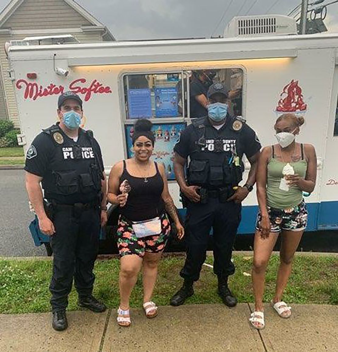 Camden County police pose with residents outside a Mister Softee ice cream truck. 