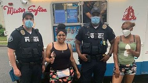 Camden County police pose with residents outside a Mister Softee ice cream truck. 