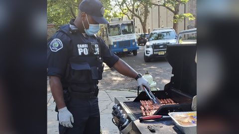 An officer in Camden County, New Jersey, grills hot dogs for one of the department's pop-up neighborhood parties. The city has reformed its police department to focus on de-escalating violence in the community.