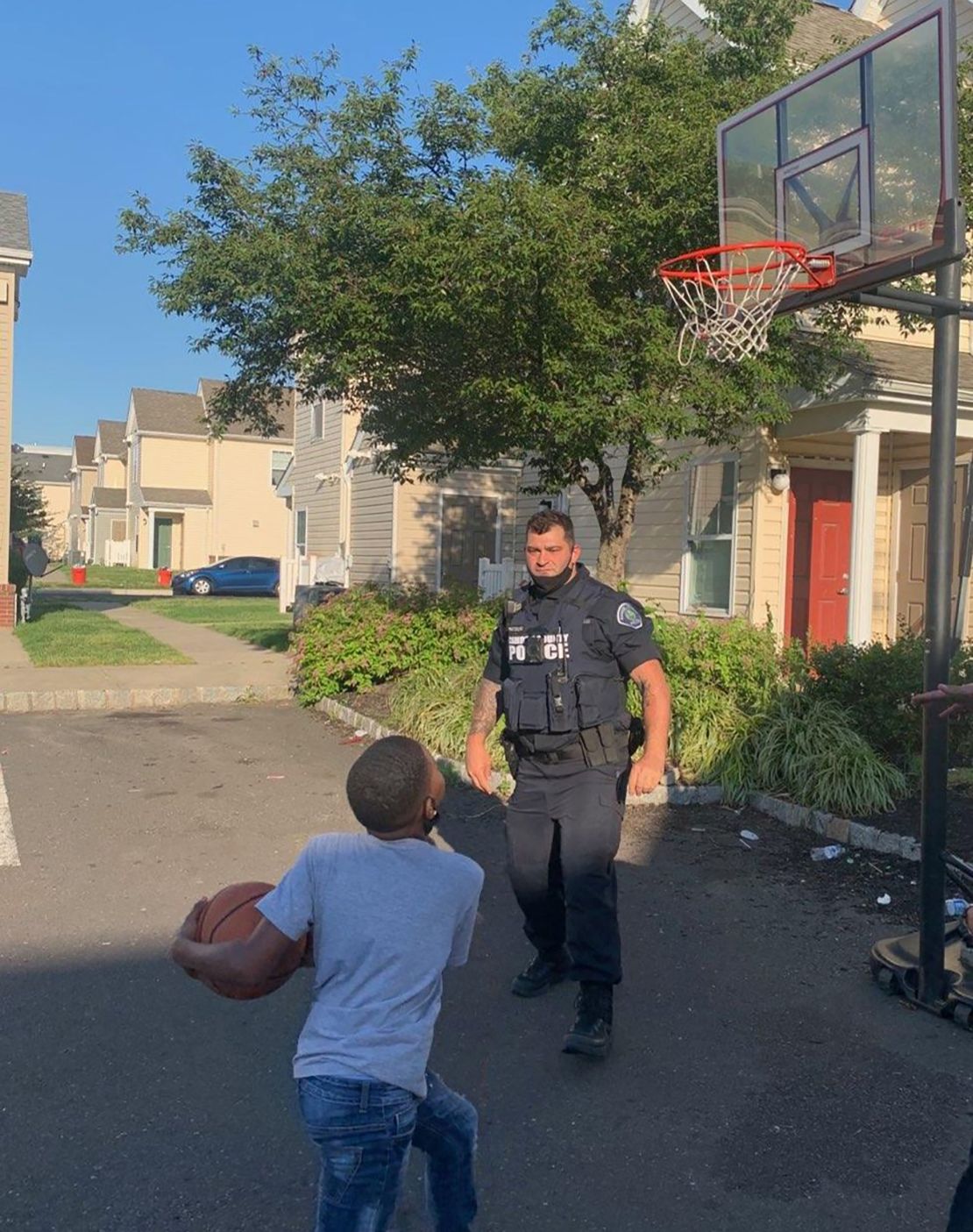 A Camden County officer plays basketball with a young resident.