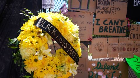 A wreath is seen in front of messages on the security fence on the north side of Lafayette Square, near the White House.
