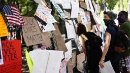 People look at posters and placards on the security fence on the north side of Lafayette Square, near the White House, in Washington, DC on June 8, 2020.