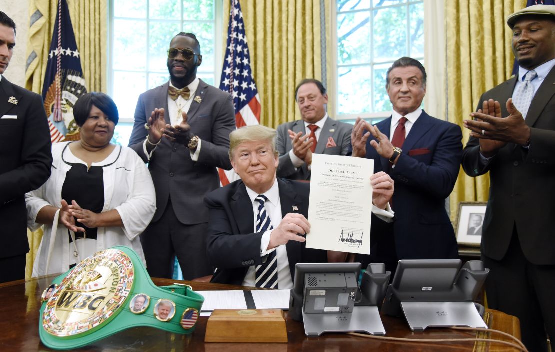 US President Trump holds a signing Executive Grant of Clemency for Johnson in the Oval Office with Deontay Wilder (second left) and Lennox Lewis (far right) in attendance. 