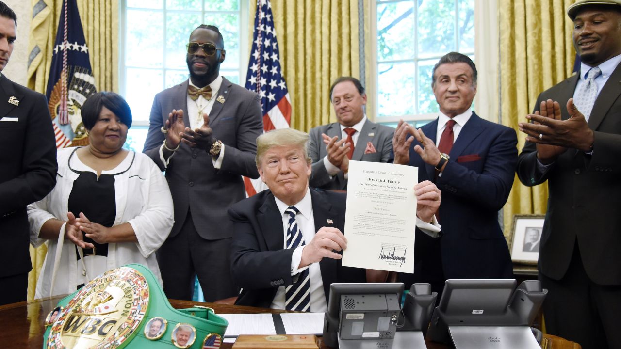 US President Trump holds a signing Executive Grant of Clemency for Johnson in the Oval Office with Deontay Wilder (second left) and Lennox Lewis (far right) in attendance. 