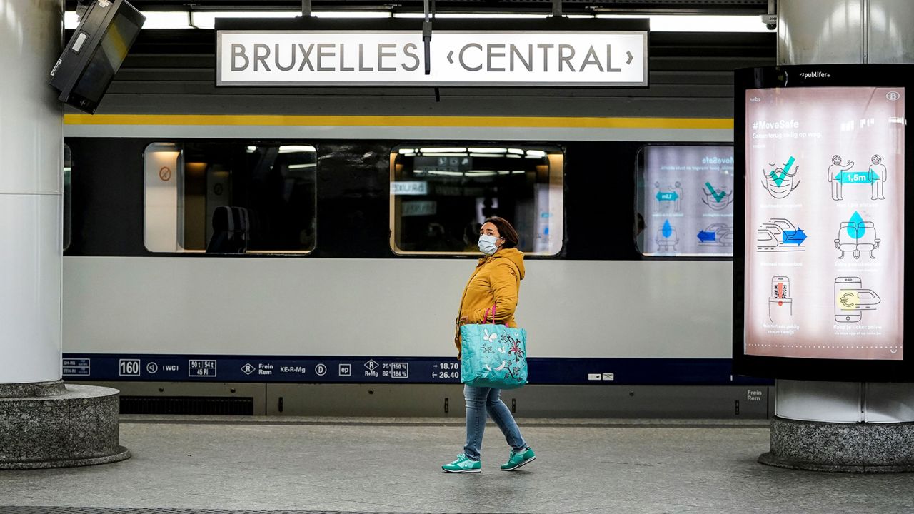 A commuter wearing a protective face mask waits for a train at the Gare Bruxelles-Central train station. 