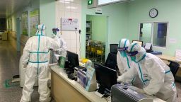 TOPSHOT - This photo taken on January 22, 2020 shows medical staff members wearing protective suits at the Zhongnan hospital in Wuhan in China's central Hubei province. - China banned trains and planes from leaving Wuhan at the centre of a virus outbreak on January 23, seeking to seal off its 11 million people to contain the contagious disease that has claimed 17 lives, infected hundreds and spread to other countries. (Photo by STR / AFP) / China OUT (Photo by STR/AFP via Getty Images)