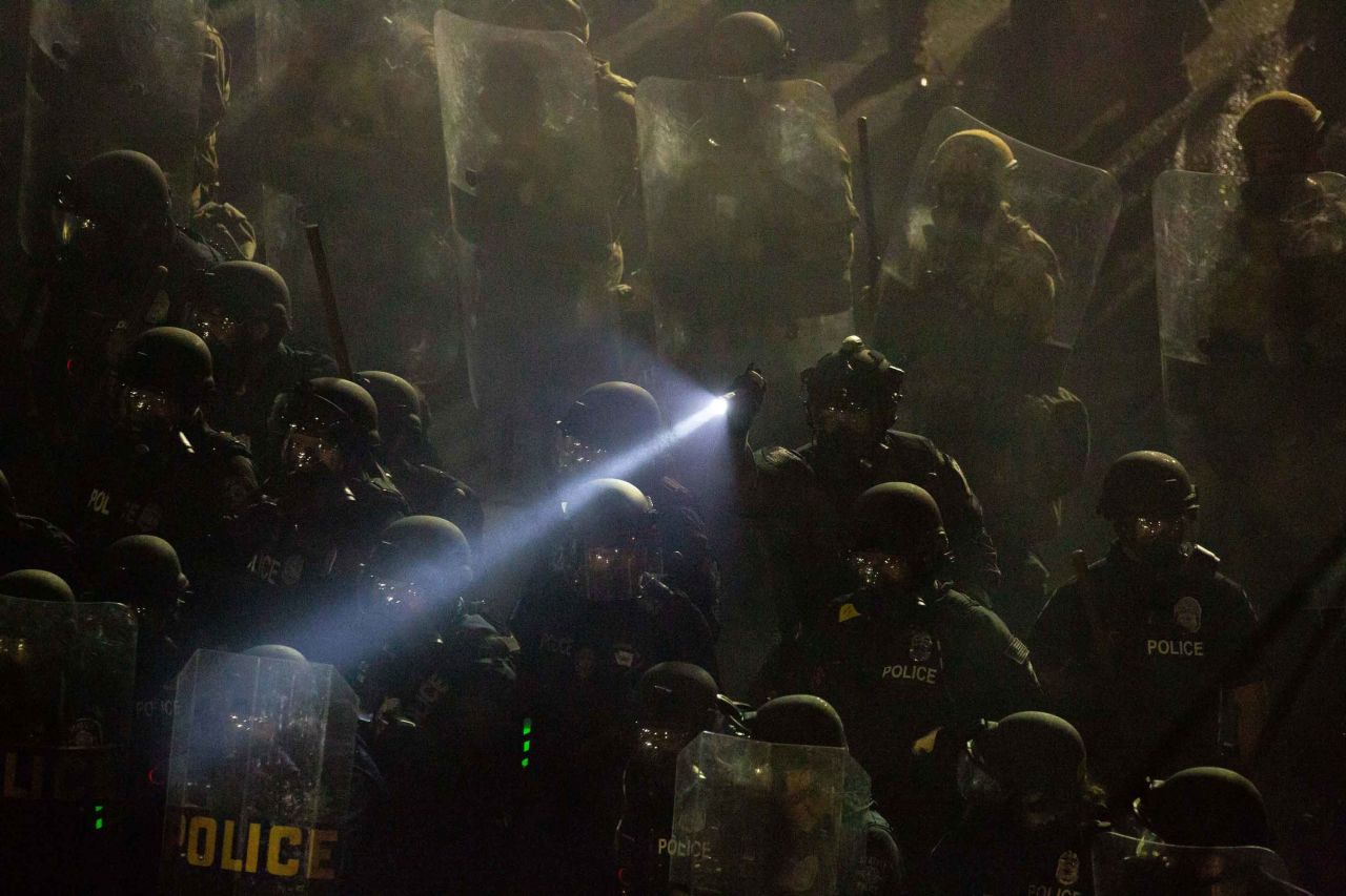 Seattle Police and Washington National Guard personnel retake control of an intersection as demonstrators clash with law enforcement near the Seattle Police Department's East Precinct shortly after midnight on June 8. 