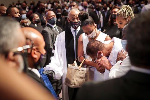 Mourners react as Floyd's extended family walks into his funeral service on Tuesday.