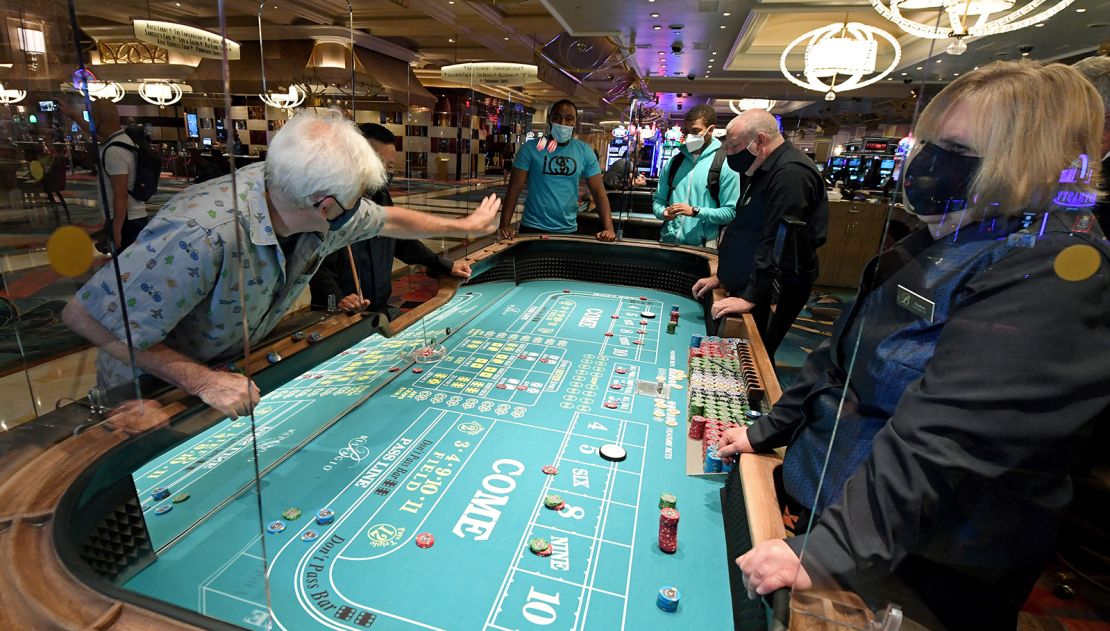 Guests play craps on a table with plexiglass safety shields at Bellagio Resort & Casino.