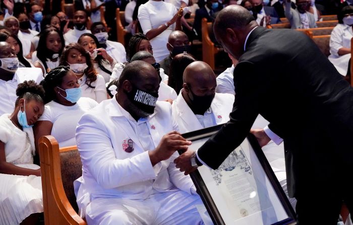 Houston Mayor Sylvester Turner hands Floyd's family a proclamation during Tuesday's funeral. Turner proclaimed that June 9 will be <a href="index.php?page=&url=https%3A%2F%2Fwww.cnn.com%2Fus%2Flive-news%2Fblack-lives-matter-protests-george-floyd-06-09-2020%2Fh_09e522627996d432e59afe9e7e2fa02d" target="_blank">"George Perry Floyd Day"</a> in the city of Houston.