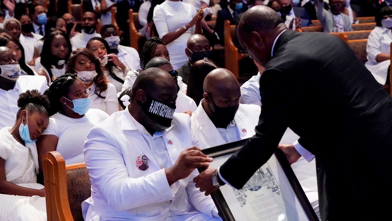 Houston Mayor Sylvester Turner hands the family a proclamation family and guests attend the funeral service for George Floyd at The Fountain of Praise church on June 9, 2020, in Houston. - George Floyd will be laid to rest Tuesday in his Houston hometown, the culmination of a long farewell to the 46-year-old African American whose death in custody ignited global protests against police brutality and racism.Thousands of well-wishers filed past Floyd's coffin in a public viewing a day earlier, as a court set bail at $1 million for the white officer charged with his murder last month in Minneapolis. (Photo by David J. Phillip / POOL / AFP) (Photo by DAVID J. PHILLIP/POOL/AFP via Getty Images)