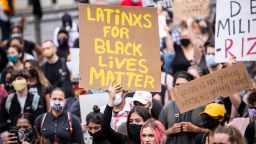 MANHATTAN, NY - JUNE 02: A  protester holds a sign that says, "LATiNXS FOR BLACK LiVES MATTER" among the large crowd in Foley Square.  Protesters took to the streets across America after the killing of George Floyd at the hands of a white police officer Derek Chauvin that was kneeling on his neck during his arrest as he pleaded that he couldn't breathe. The protest are attempting to give a voice to the need for human rights for African American's and to stop police brutality against people of color.  Many people were wearing masks and observing social distancing due to the coronavirus pandemic.  Leaders of the protest were clear that they wanted it to be a peaceful protest in light of nights of unrest looting and destruction.  Photographed in the Manhattan Borough of New York on June 02, 2020, USA.  (Photo by Ira L. Black/Corbis via Getty Images)